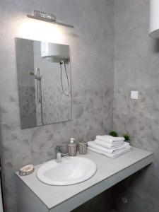 a bathroom with a white sink and a mirror at Tara Deluxe Apartment in Budva +8 photos