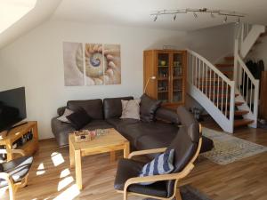 sala de estar con sofá y mesa en Strandperle - Ihre Ferienwohnung en Schönhagen