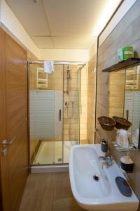 Un baño con lavabo blanco y ducha. en Chiaia Relax, en Nápoles