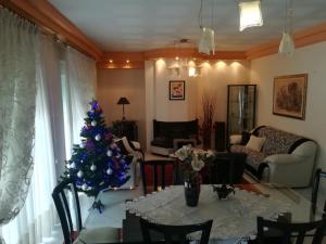 un árbol de Navidad en una sala de estar con mesa en Apartment Volos, en Volos