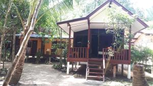 a small house with a porch and a tree at Moonhut Bungalows in Mae Nam