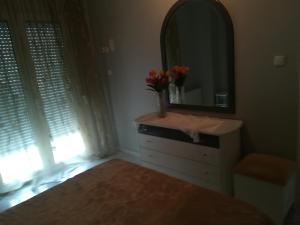 Dormitorio con tocador con espejo y flores en Apartment Volos, en Volos
