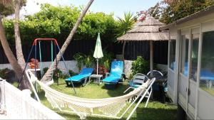 a backyard with chairs and a swing and an umbrella at Country House Alfarim in Alfarim