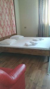 a large bed in a room with a red chair at MEDI Guest House in Osh
