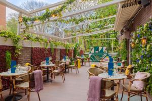 a restaurant with tables and chairs under a pergola at Iveagh Garden Hotel in Dublin