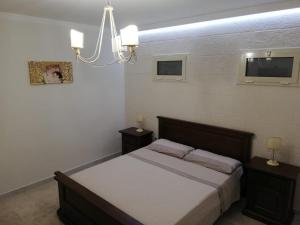 um quarto com uma cama e um lustre em Casa Vacanze LIBERTY em Licata