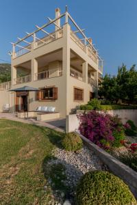 a white house with a balcony and a yard at Villa Belvedere in Kyparissia