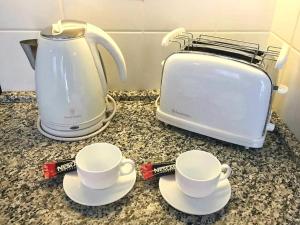 two coffee cups and a toaster on a counter at Apartment Jastuk in Belgrade