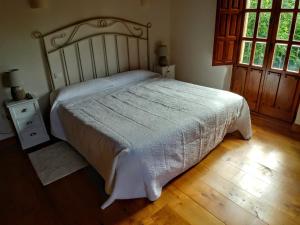 ein Schlafzimmer mit einem großen Bett und Holzboden in der Unterkunft Trisileja en Novales in Novales