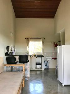 a kitchen with a white refrigerator and a sink at Vila dos Cristais in Alto Paraíso de Goiás