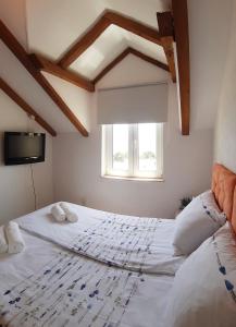 a bedroom with a large white bed with a window at Liliana Bol Apartment with Wonderful Sea View Near the Beaches in Bol