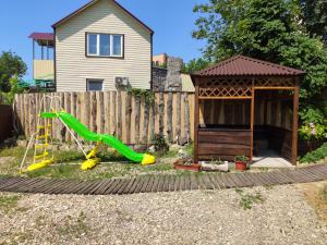 a backyard with a slide and a gazebo at Rodnoy Prichal Guest House in Arkhipo-Osipovka