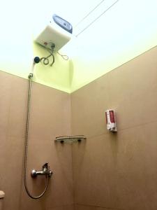 baño con ducha y una cámara en la pared en Villa Safira, en Batu