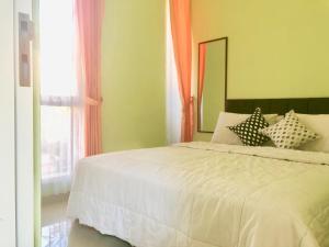 Un dormitorio con una cama blanca y una ventana. en Villa Safira, en Batu