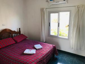 a bedroom with a bed with two towels on it at Departamentos "La Perla" in Andalgalá