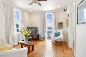 a living room with a white couch and a tv at Freret Apartments near Streetcar & Tulane in New Orleans
