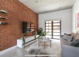 a living room with a brick wall at Trendy Melrose Apartment in Johannesburg