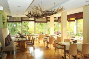 a restaurant with tables and chairs and a chandelier at Parkhotel in Bad Wünnenberg