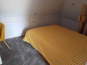 a small bedroom with a bed with an orange comforter at Angers Green Lodge - Yellow Sun Appartement in Angers
