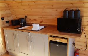 eine Küche mit einer Theke mit einer Mikrowelle und einer Mikrowelle in der Unterkunft Shiskine Pod in Aultgrishin
