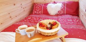 a basket of fruit on a table with two cups of coffee at Shiskine Pod in Aultgrishin