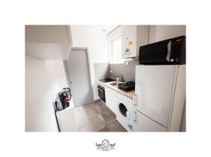 Il comprend une petite cuisine équipée d'un réfrigérateur et d'un four micro-ondes. dans l'établissement La Suite T2 40m2 avec terrasse 1ch-4pers Appart Hotel Poitiers, à Poitiers