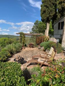 a patio with chairs and a fire pit in a yard at La Fontanella Country House in Celle sul Rigo