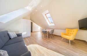 a living room with a blue couch and a yellow chair at Lilu Apartamenty in Dziwnów