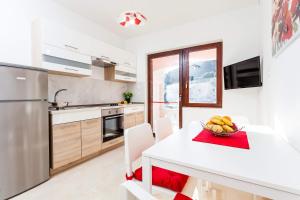 a kitchen with a table with a bowl of fruit on it at Apartment Jakov Grscica in Prizba