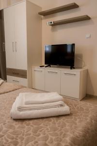 a bedroom with a flat screen tv on a bed at Margis Home in Burgas
