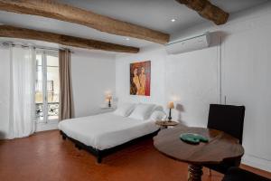 a bedroom with a bed and a table and a window at Maison Carles BnB in La Colle-sur-Loup