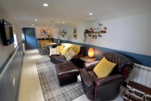 un salon avec des canapés en cuir et une télévision dans l'établissement Craiglockhart Lodge, à Édimbourg