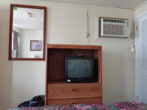 a television sitting on a dresser in a bedroom at Fountain Motel in Wildwood