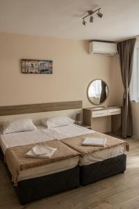 a bedroom with a large bed and a mirror at Margis Home in Burgas