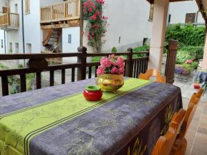 a table with a vase of flowers on a balcony at L'Antica Canonica di Casa Bernardi, terrazzo Wi-Fi PetFriendly con Area Cani in Trento