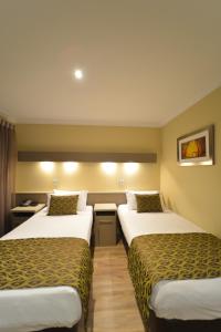 una habitación de hotel con 2 camas en una habitación en Bentley Motel en Perth