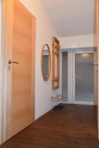 a hallway with a wooden door and a mirror at Gästehaus Palli in Unterdietfurt