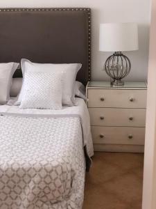 a bedroom with a bed and a lamp on a dresser at ATICO SAN MARCOS in El Puerto de Santa María