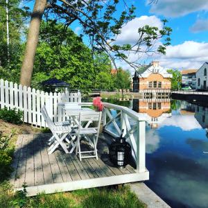 une table et des chaises sur une terrasse en bois à côté de l'eau dans l'établissement Berglings Boutique Hotell, à Norrtälje