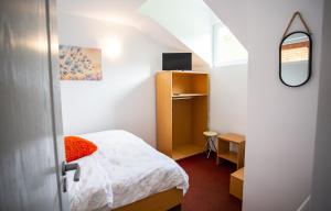 Dormitorio pequeño con cama y espejo en Complex Cazare Balea Transfagarasan, en Cârţişoara