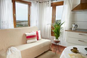 Una sala de estar con un sofá y una ventana. en Villa Nueva, en Mala