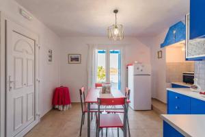 a kitchen with a table and chairs and a refrigerator at BLUE PARADISE SUITES in Pachaina