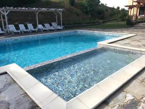 a large swimming pool with chairs and a pool at Hotel Enchevi in Kirkovo