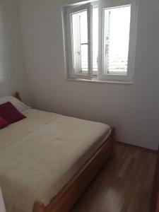 1 dormitorio con cama y ventana en Lilo, en Maslinica