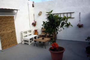 a patio with a bench and a table and a tree at Le stanze di Cortès in Fragagnano