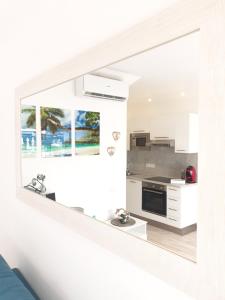 a kitchen with white walls and a large mirror at Renovated House Front-Pool in Maspalomas