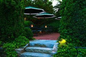 eine Terrasse mit einem Tisch, Stühlen und Sonnenschirmen in der Unterkunft Union Street Inn in Nantucket