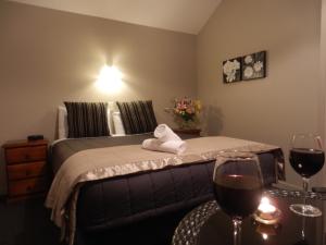 a bedroom with a bed with two glasses of wine at Lake Wanaka Lodge in Wanaka