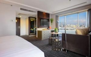 a hotel room with a bed and a television at Midas Hotel and Casino in Manila