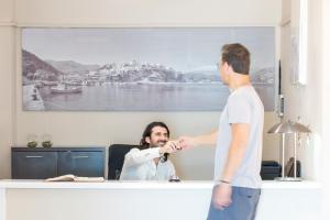 a man helping another man tie his tie at Galini Mare in Agia Galini